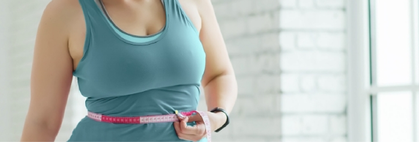 Woman measuring her waistline for excess weight